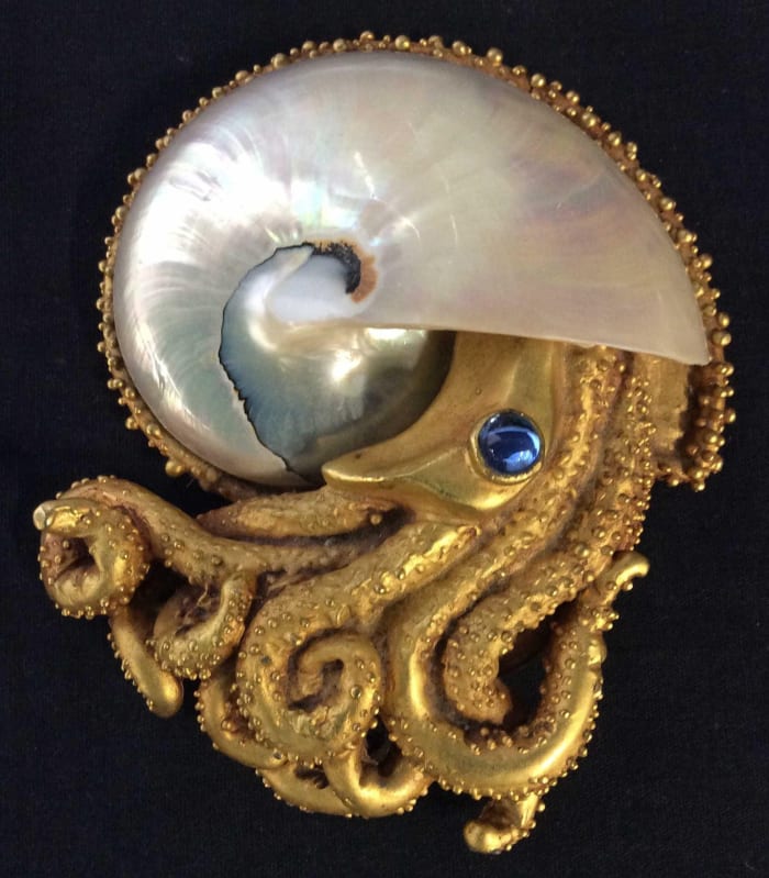 A gold leaf and shell octopus figural tabletop with blue glass eye, signed Lazaro, 6" x 4-1/2". Sold by The Benefit Shop Foundation Inc. through LiveAuctioneers for $600.