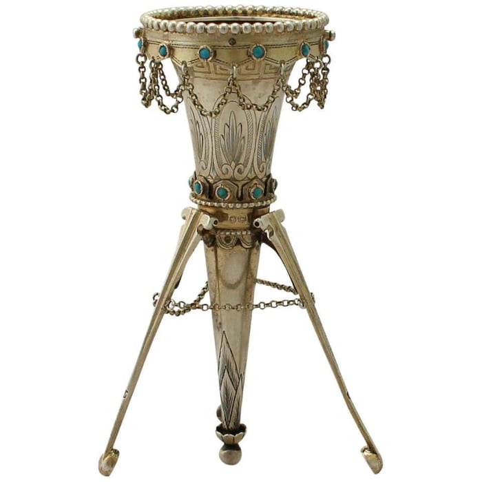 Victorian sterling silver posy holder, 1874, conical shaped form on three legs, embellished with bright cut engraved Greek Key fret band ornamentation and stylized leaves, beads, a scalloped border and collet-set cabochon turquoise, 5” h; $2,883.