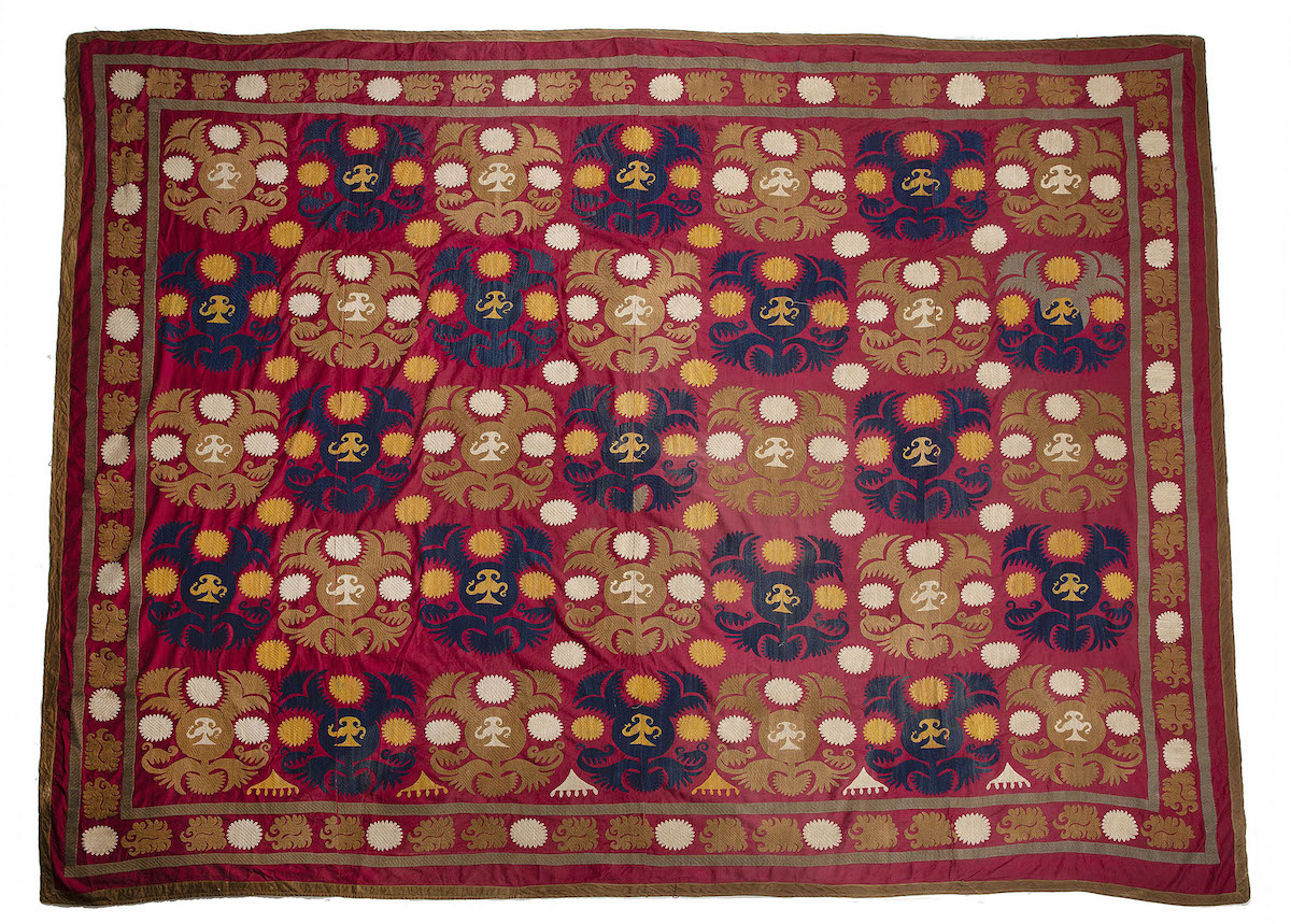 A large red ground suzani, also from Uzbekistan circa 1940. Woven with coffee pots and carnations
