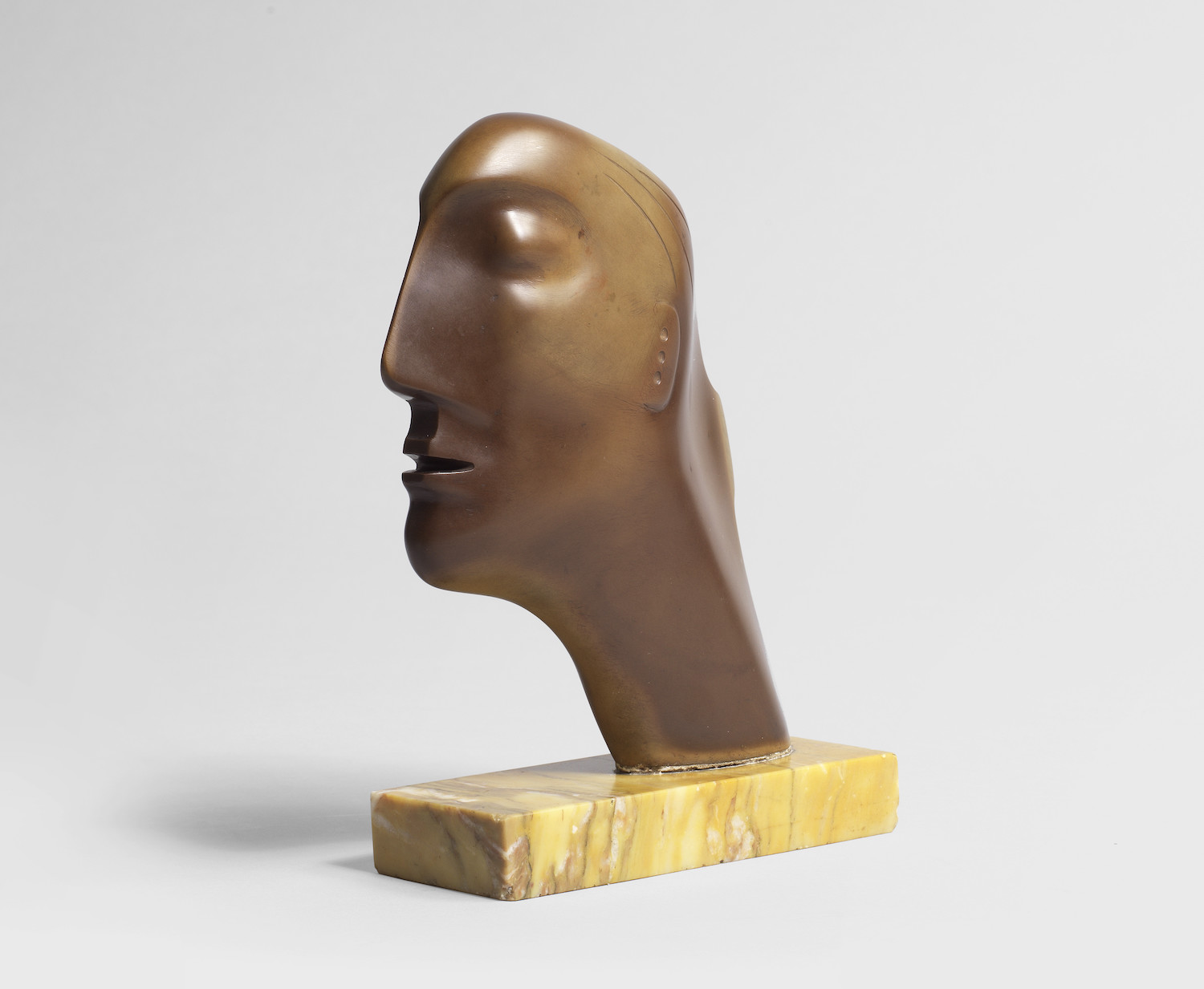 Henry Moore O.M., C.H. (British, 1898-1986) Head ironstone on a marble base