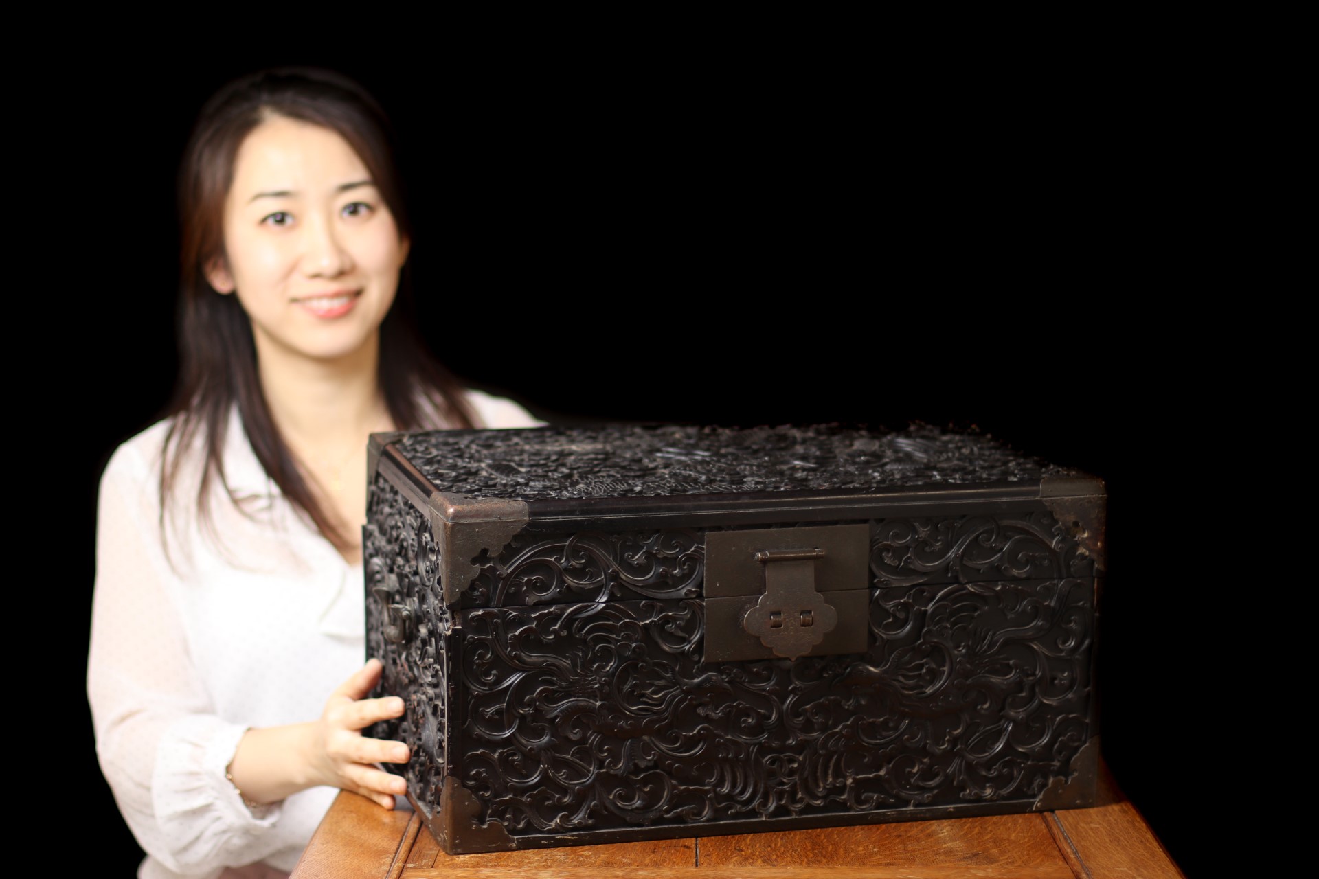 Woman holding antique Chinese box made from zitan