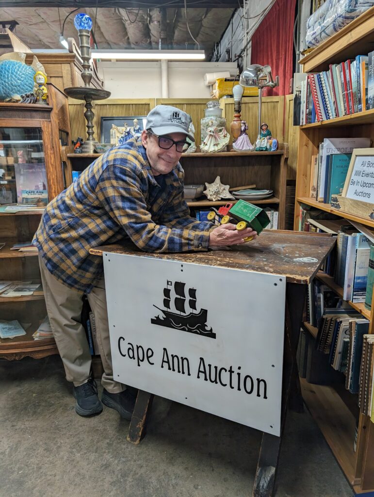 Walt Kolenda of Cape Ann Auction in Gloucester, Massachusetts, holds a tin toy truck 