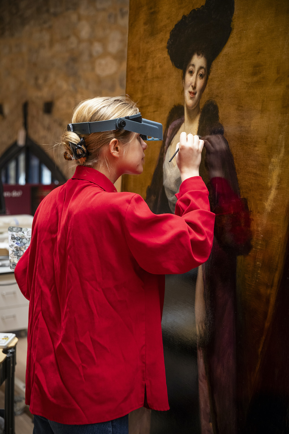 Conservator working on 19th century oil painting at the Royal Oak Foundation studio at Knole, Kent. Oil painting on canvas, Margaret Anderson, The Hon. Mrs Ronald Greville DBE (1863-1942) by Emile-Auguste Carolus-Duran (Lille 1838 - Paris 1917)