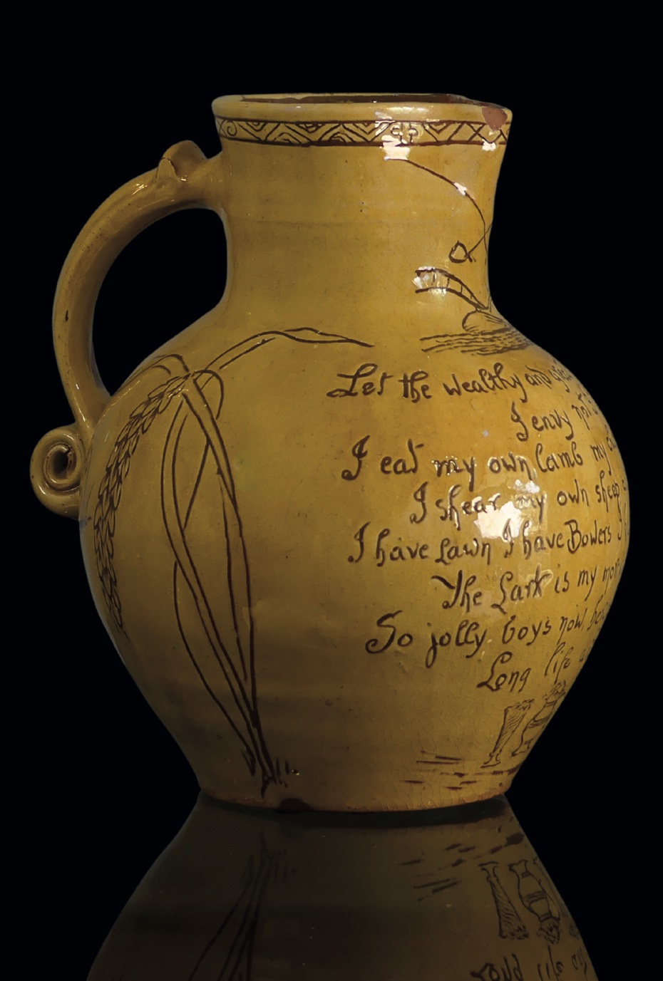 A Fishley Potter harvest jug decorated with a fine yellow slip over a honey-coloured base