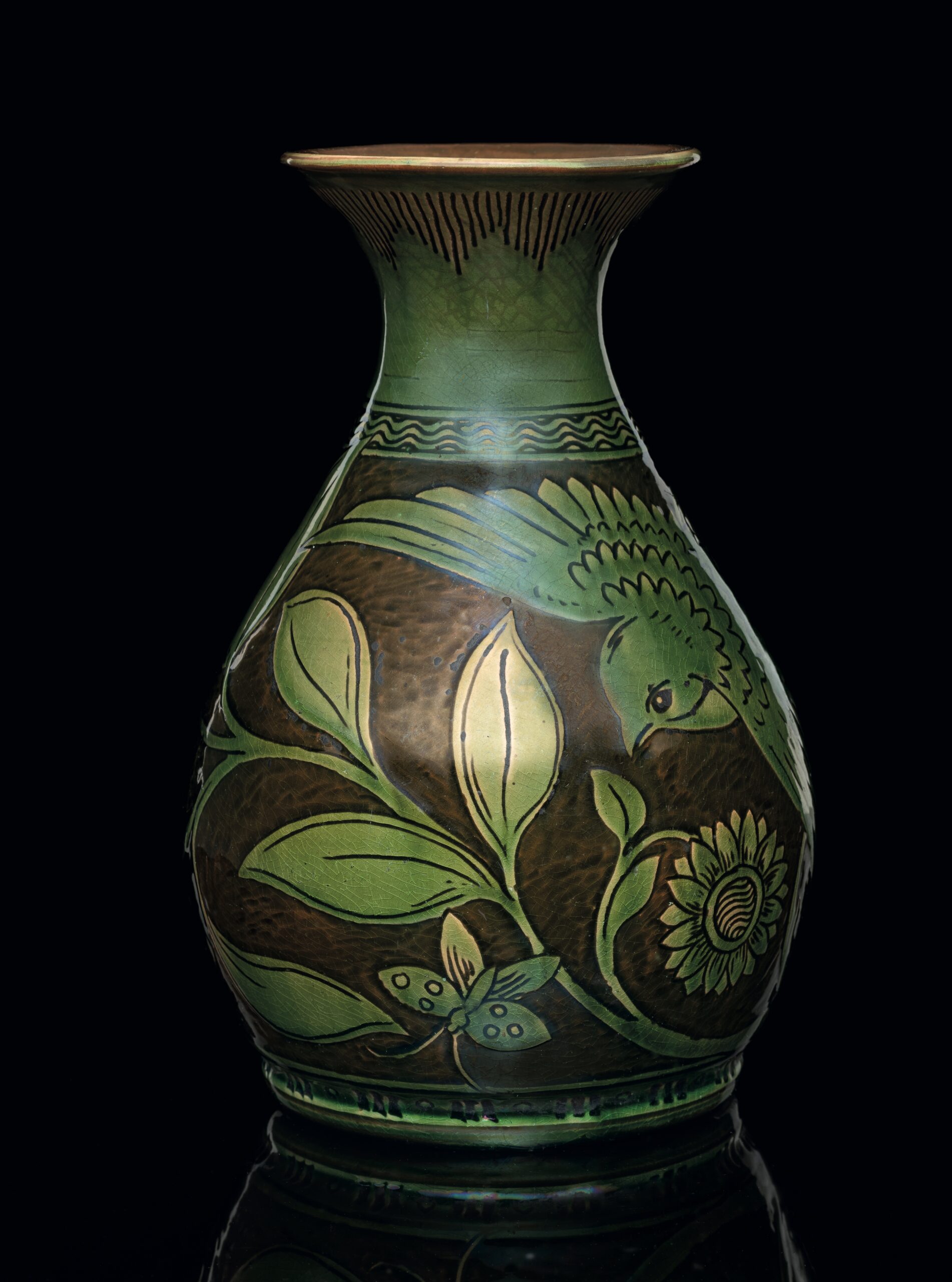 A Fremington Pottery vase in the arts and crafts style by Edwin Beer Fishley (1832-1912) decorated with a bird among flora in slipware and sgraffito, with a lustrous glaze